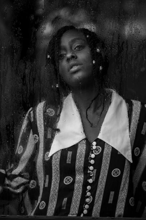 女人站在窗前的灰度摄影 · 免费素材图片