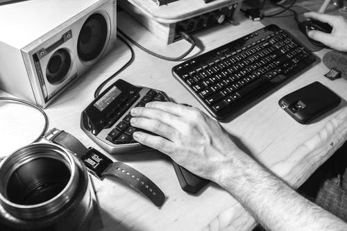 人类左手靠近电脑键盘的灰度摄影 · 免费素材图片