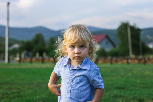 可爱的小女孩，穿着蓝色的纽扣衬衫 · 免费素材图片