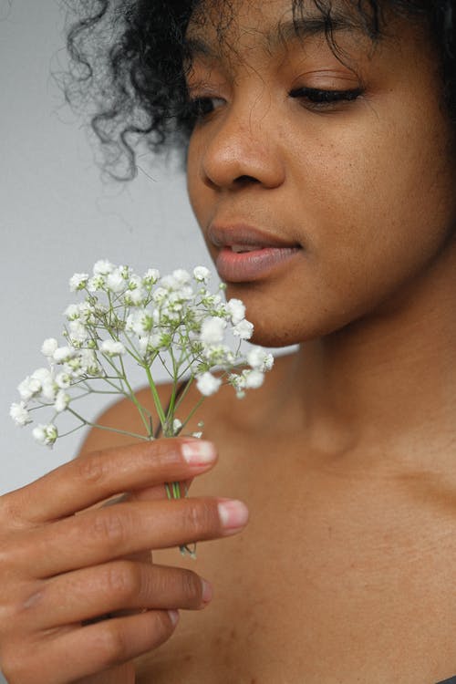 女人抱着白花花束 · 免费素材图片
