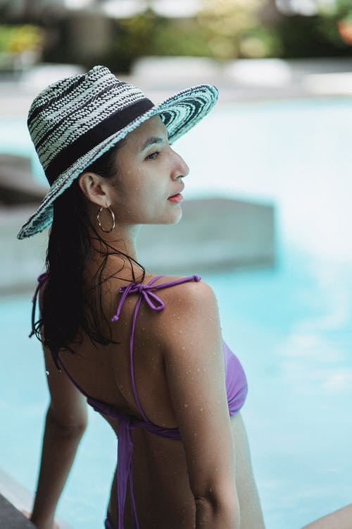 冷静在现代酒店领土上的游泳池附近放松的年轻族裔妇女 · 免费素材图片