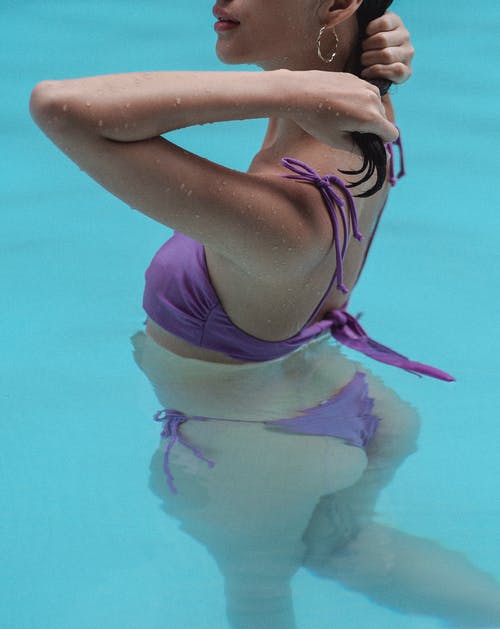 无法认出的美丽的女人，在游泳池里放松的同时抚摸头发 · 免费素材图片