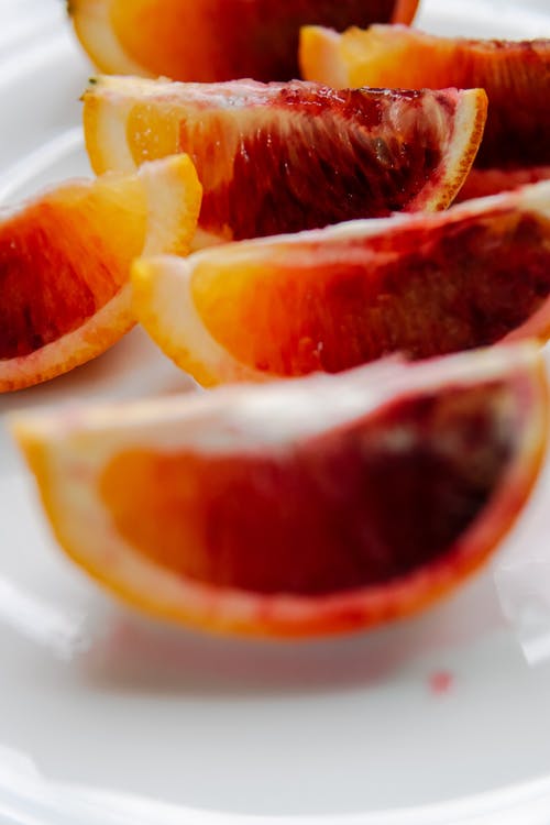 在白色陶瓷板上切橙色的水果 · 免费素材图片