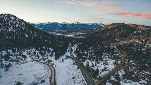 树木和山脉之间的道路鸟瞰图 · 免费素材图片