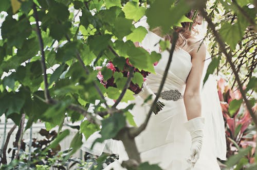 女人穿着白色婚纱附近绿树 · 免费素材图片