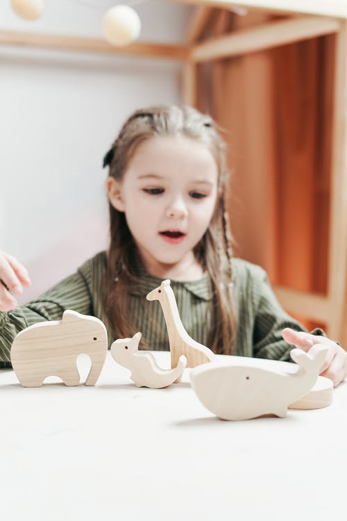 女孩玩木制玩具动物 · 免费素材图片