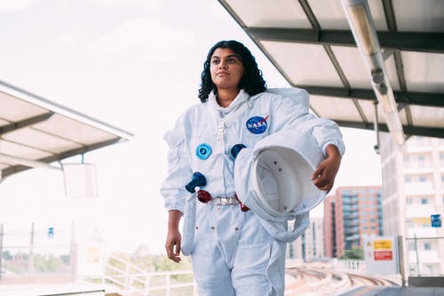 女人在火车站穿太空服 · 免费素材图片