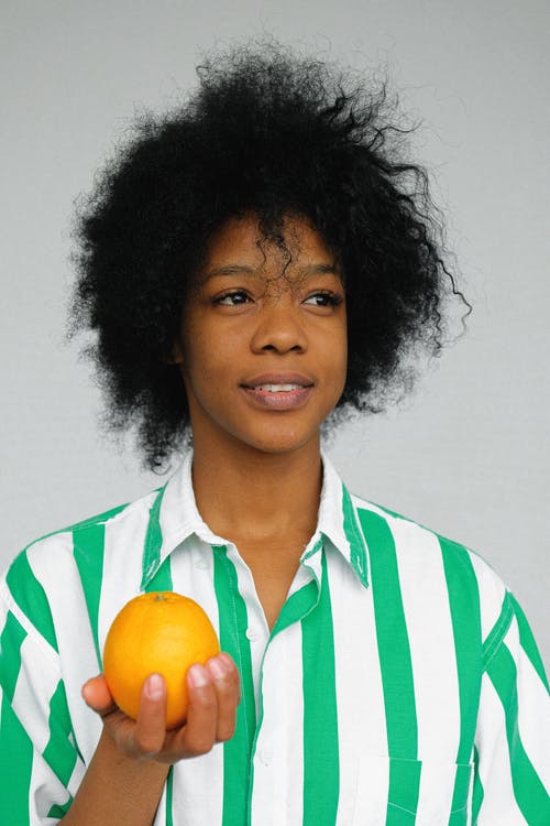 女人的肖像照片穿着橙色水果的白色和绿色条纹衬衫 · 免费素材图片