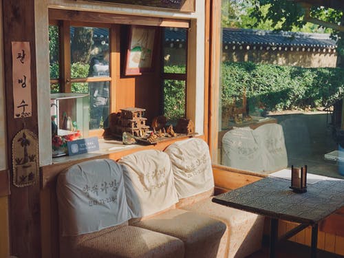 棕色的木桌，靠近棕色的沙发椅 · 免费素材图片