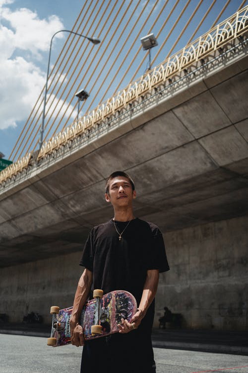 梦幻般的民族运动员，对城市桥梁的滑板 · 免费素材图片