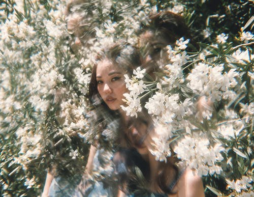 躺在白花上的黑色背心的女人 · 免费素材图片