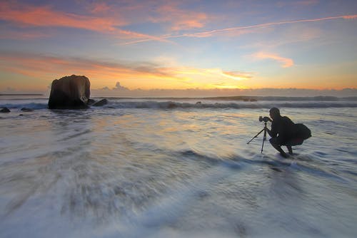 男人在黄金时段在水体上拍照海洋 · 免费素材图片