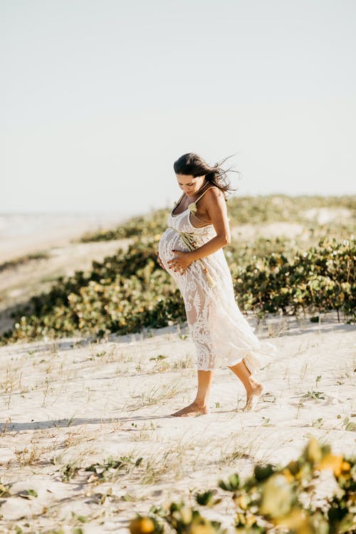 孕妇在沙滩上散步的白色连衣裙 · 免费素材图片