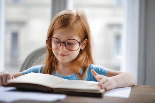 蓝衬衫，戴着眼镜，看书的女孩 · 免费素材图片