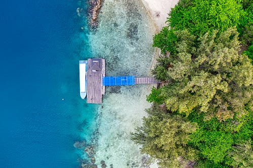 海岸线上的蓝色和灰色木船坞鸟瞰摄影 · 免费素材图片