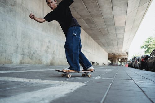 性格开朗的亚洲人，骑在滑板上 · 免费素材图片