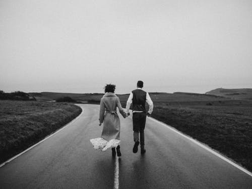 夫妻在路上行走的灰度照片 · 免费素材图片