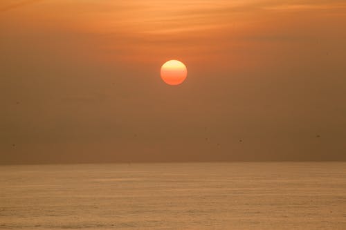 太阳落在平静荡漾的大海 · 免费素材图片