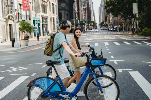 亚洲夫妇与自行车在人行横道上行走 · 免费素材图片