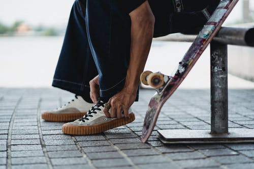 牛仔布感人的运动鞋的滑板在混凝土砖附近的滑板的人 · 免费素材图片