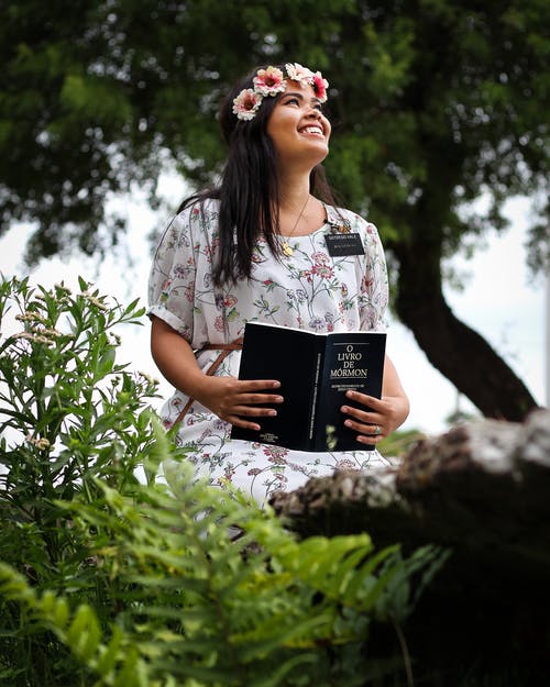 女人穿着白色的花裙子，拿着本书 · 免费素材图片