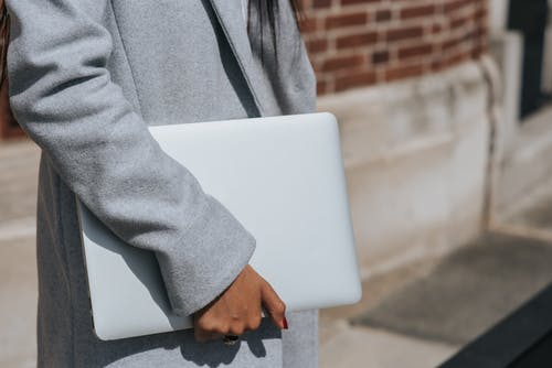 用笔记本电脑在城市路面上的匿名民族女商人 · 免费素材图片