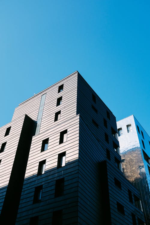 蓝蓝的天空下灰色混凝土建筑的低角度摄影 · 免费素材图片