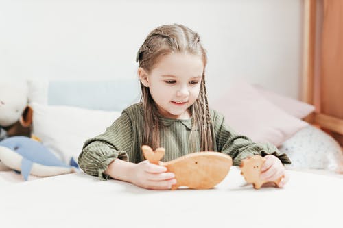 女孩玩木制玩具的照片 · 免费素材图片