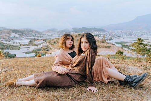 两个女人坐在山上 · 免费素材图片