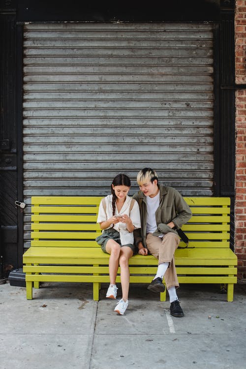 冷静夫妇坐在大街上的长椅上 · 免费素材图片