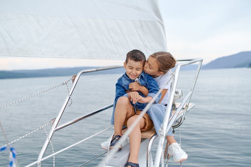 在帆船上亲吻哥哥的小女孩 · 免费素材图片