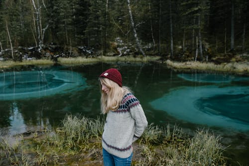 女性在湖岸上用蓝色的水 · 免费素材图片