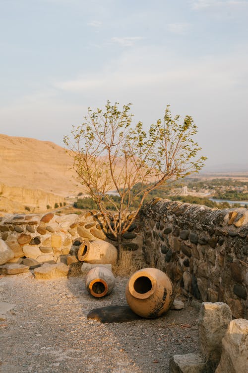 在古建筑的石墙附近的陶壶 · 免费素材图片
