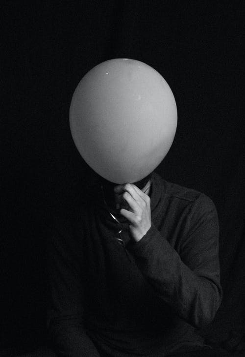人用气球遮住脸的灰度照片 · 免费素材图片