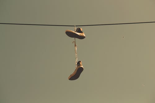 白色黑色高帮鞋挂在电线上 · 免费素材图片