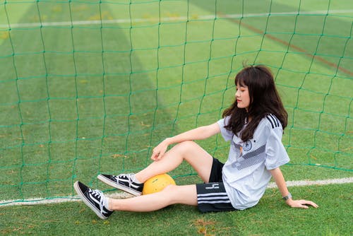 女人坐在足球门 · 免费素材图片