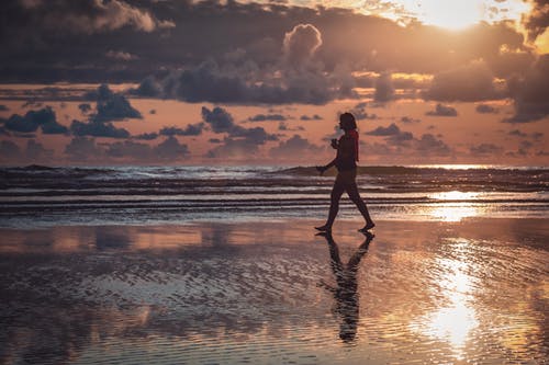 在海边散步的人的身影 · 免费素材图片