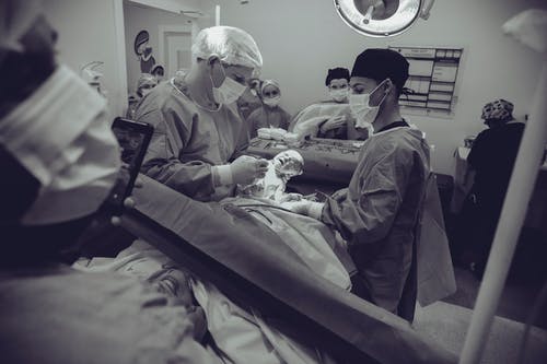抱着婴儿的医生的灰度摄影 · 免费素材图片
