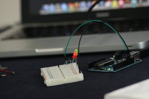 笔记本电脑旁边的白色和绿色计算机零件 · 免费素材图片