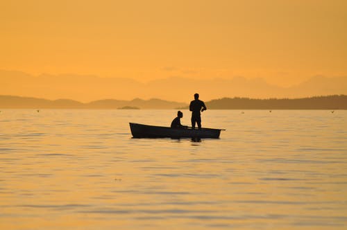 2个人站在一条小船在水上 · 免费素材图片