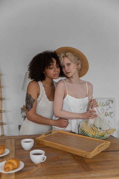 多种族的女同性恋夫妇在准备早餐时拥抱 · 免费素材图片