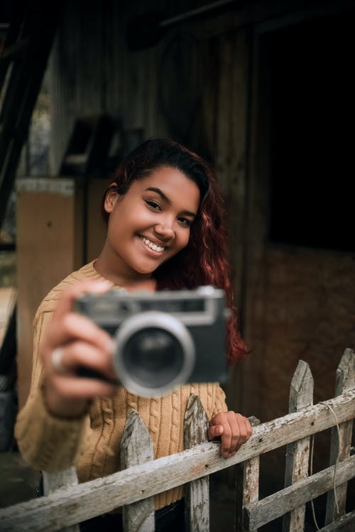 微笑着拿着照相机的女人 · 免费素材图片
