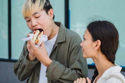亚洲人吃热狗附近年轻女友 · 免费素材图片