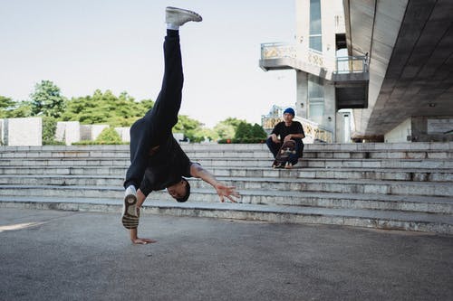 民族舞者站在手搁在楼梯上的朋友附近 · 免费素材图片