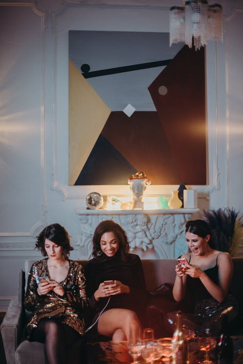 三个女人坐在棕色的沙发上 · 免费素材图片