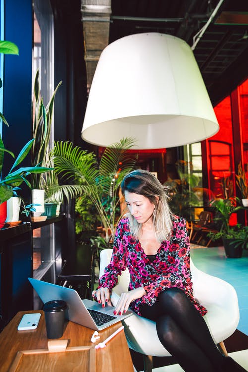 黑色和粉红色的花长袖衬衫，坐在椅子上的女人 · 免费素材图片