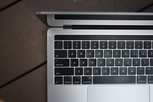 Macbook Pro在木质表面上的高角度照片 · 免费素材图片