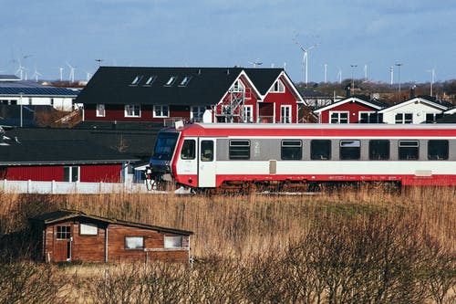 红色和白色的火车经过一个小镇 · 免费素材图片
