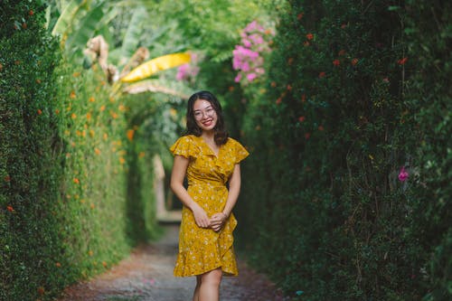 女人微笑着穿着黄色的花裙子 · 免费素材图片