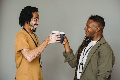 快乐的黑人同事，戴着名牌无比杯咖啡 · 免费素材图片